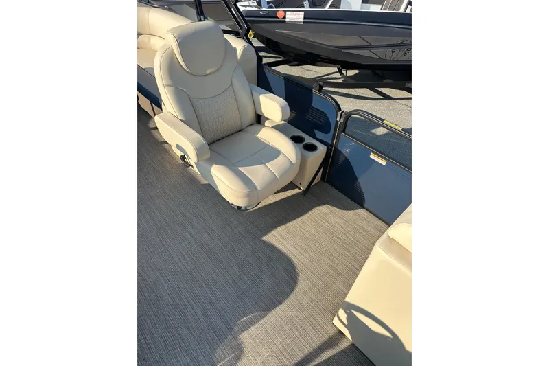 Slide: The Image of Luxurious seating on 2022 Sweetwater 2386 SB boat with beige upholstery and cup holders. - 9