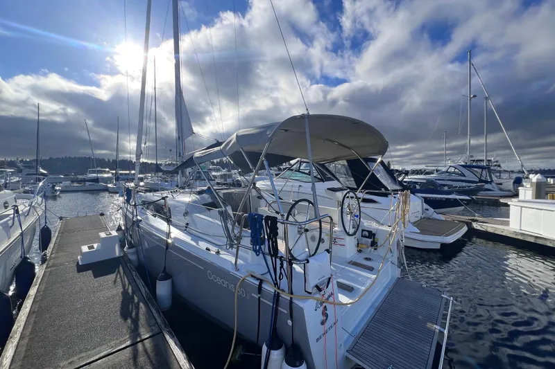 Slide: The Image of 2024 Beneteau Oceanis 30.1 sailboat docked at marina under cloudy sky. - 1