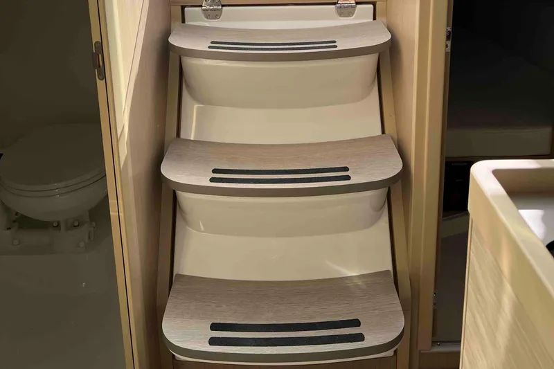 Slide: The Image of Interior stairs of 2024 Beneteau Oceanis 30.1 yacht, featuring sleek wooden design. - 19