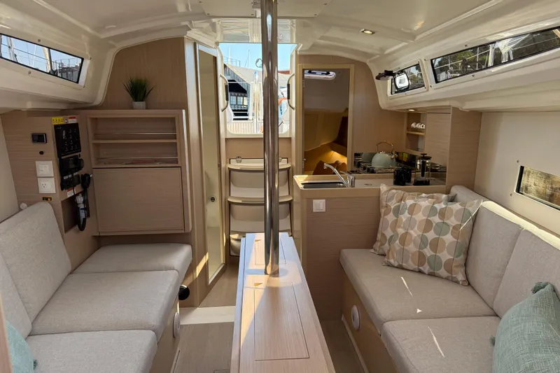 Slide: The Image of 2024 Beneteau Oceanis 30.1 yacht interior with modern seating and kitchen area. - 20