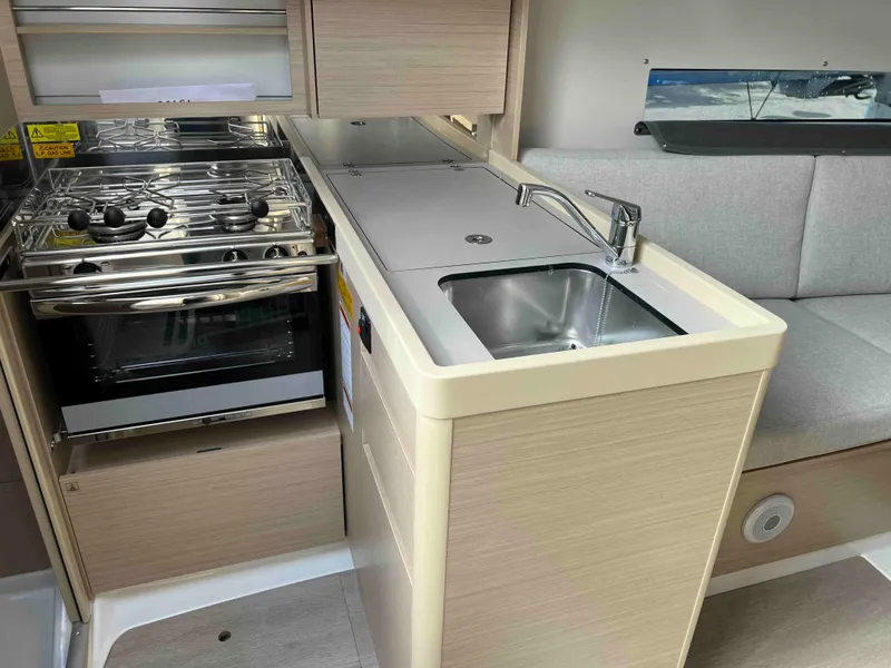 Slide: The Image of Compact kitchen area in 2024 Beneteau Oceanis 30.1 yacht with stove and sink. - 21