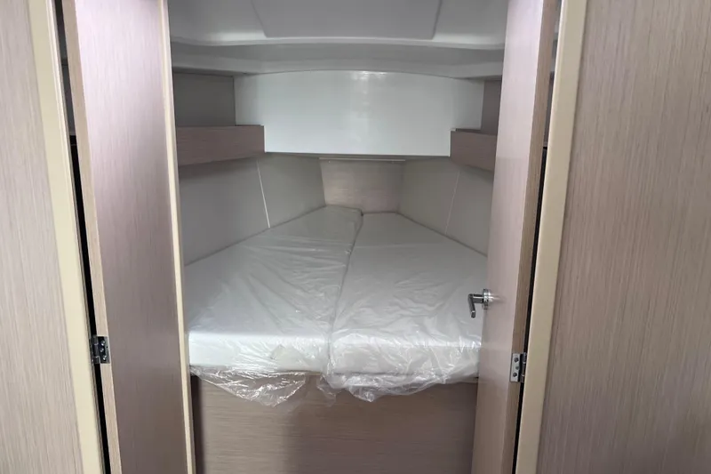 Slide: The Image of Cozy cabin interior of 2024 Beneteau Oceanis 30.1 sailboat, featuring a comfortable bed. - 30