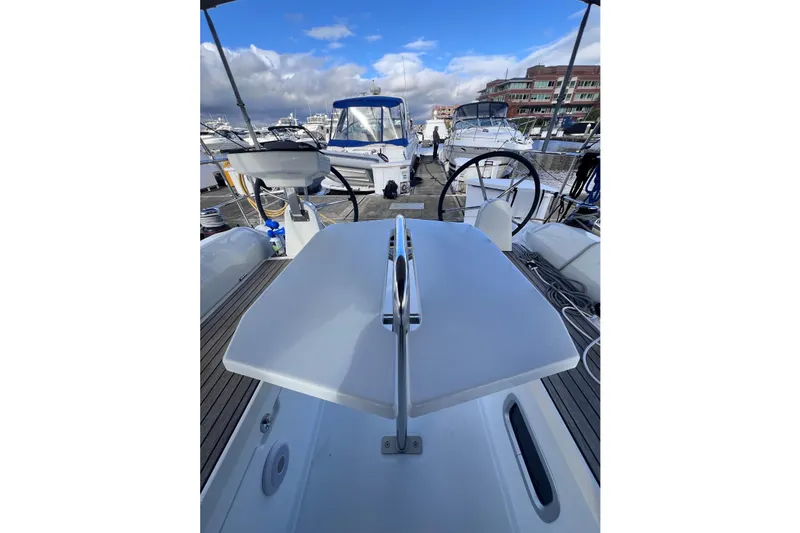 Slide: The Image of 2024 Beneteau Oceanis 30.1 yacht deck with steering wheel and marina view. - 8