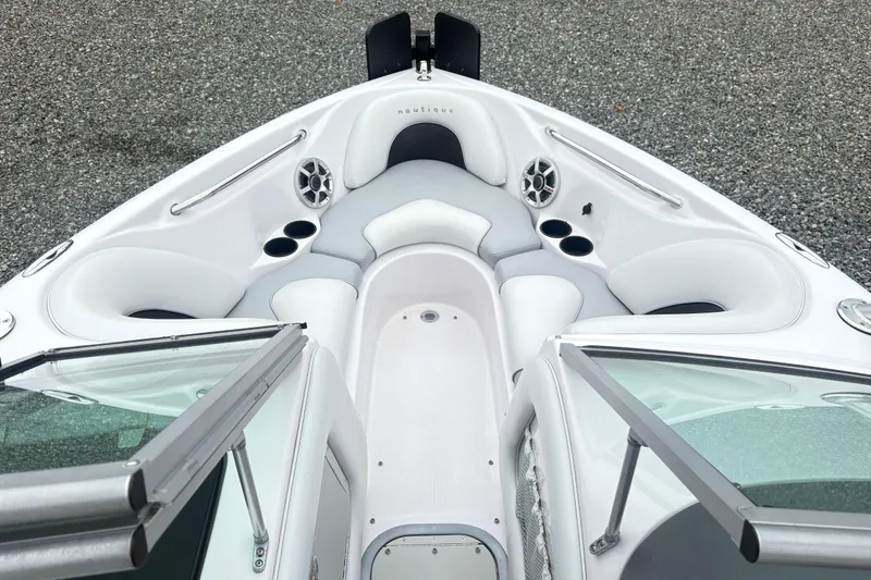 Slide: The Image of 2005 Correct Craft Nautique boat interior with white seating and cup holders. - 13