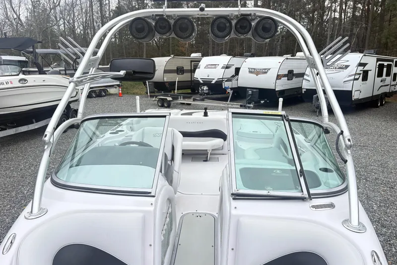 Slide: The Image of 2005 Correct Craft Nautique boat with tower speakers, parked near RVs and trailers. - 14