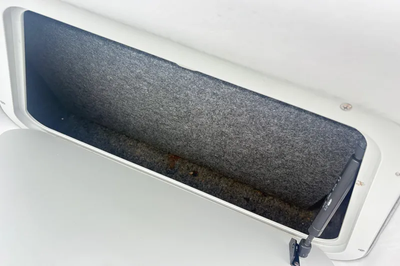 Slide: The Image of Storage compartment in a 2005 Correct Craft Nautique boat, featuring a carpeted interior. - 15