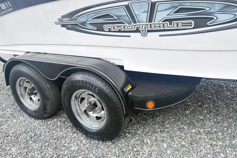 The Image of 2005 Correct Craft Nautique boat trailer with Hercules tires on gravel surface. - 5