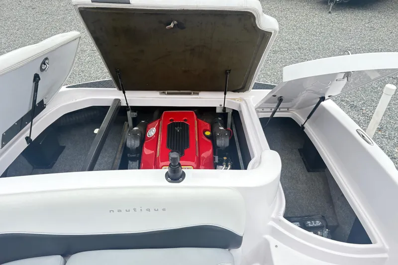 Slide: The Image of 2005 Correct Craft Nautique boat engine compartment with open hatches, showcasing red engine. - 9