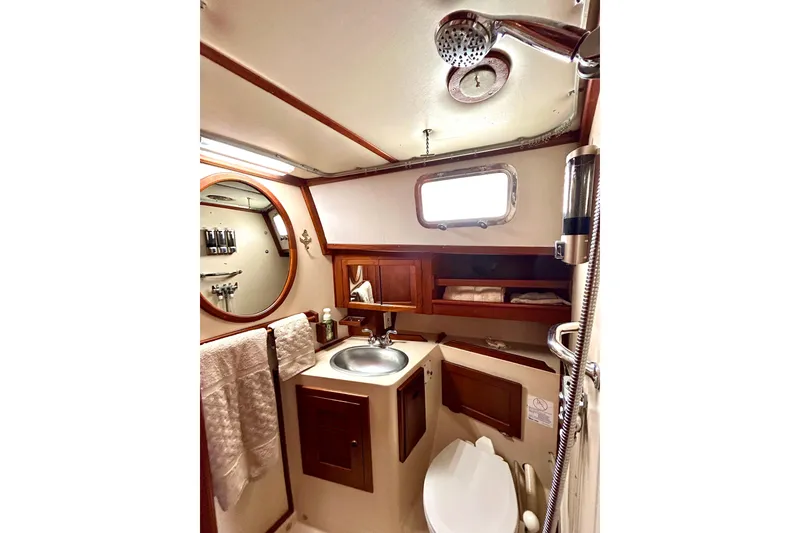 Slide: The Image of 1984 Endeavour 40 CC yacht bathroom with sink, mirror, and showerhead. - 14