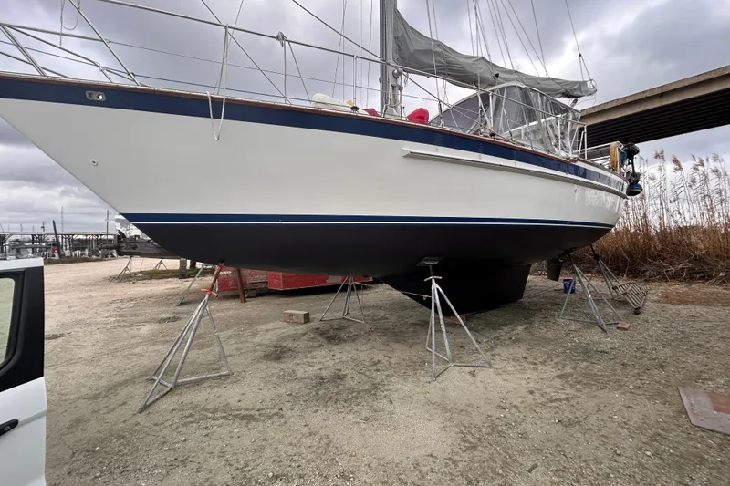 Slide: The Image of 1984 Endeavour 40 CC sailboat on stands, under cloudy sky, in a boatyard. - 4