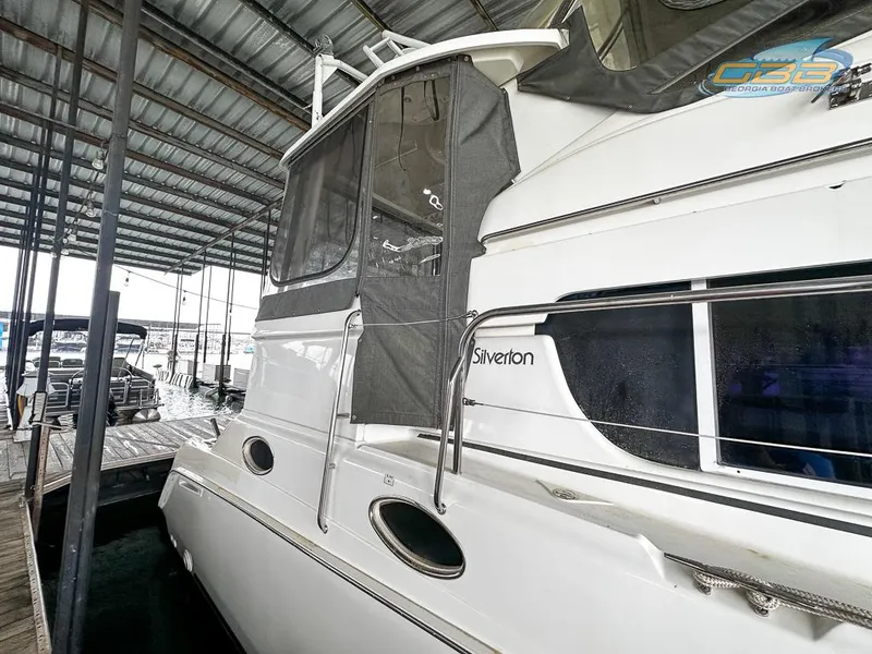 Slide: The Image of 1996 Silverton 442 Cockpit Motor Yacht docked, side view. - 14