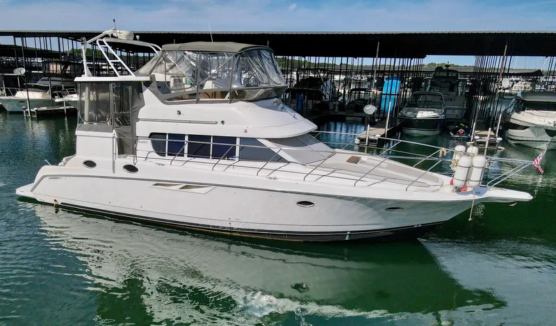 Slide: The Image of 1996 Silverton 442 Cockpit Motor Yacht docked in marina. - 2