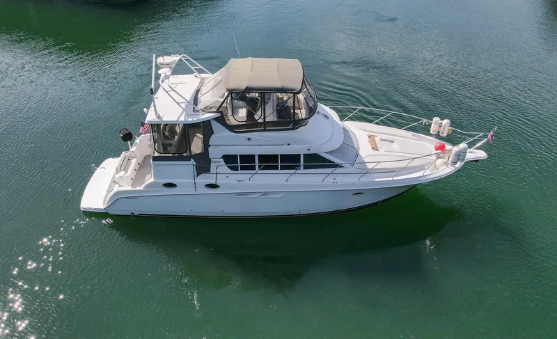 Slide: The Image of 1996 Silverton 442 Cockpit Motor Yacht on calm water. - 3