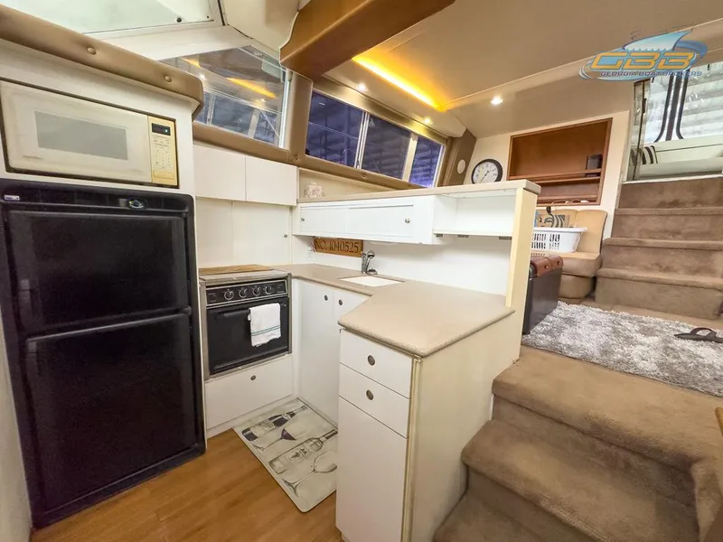 Slide: The Image of Interior of 1996 Silverton 442 Cockpit Motor Yacht with kitchen and stairs. - 33