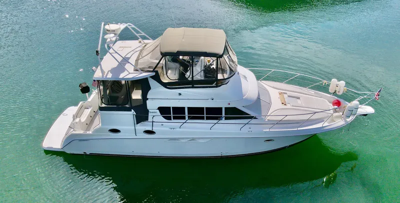 Slide: The Image of 1996 Silverton 442 Cockpit Motor Yacht on calm water. - 4