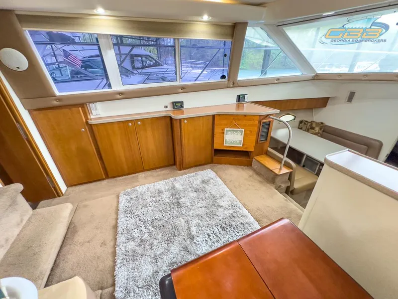 Slide: The Image of Interior of 1996 Silverton 442 Cockpit Motor Yacht with carpet and wooden furnishings. - 42