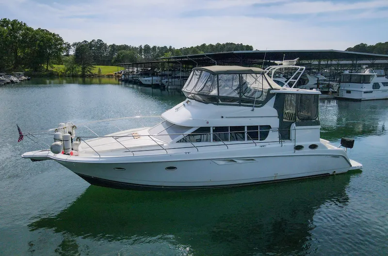 Slide: The Image of 1996 Silverton 442 Cockpit Motor Yacht on calm water. - 5