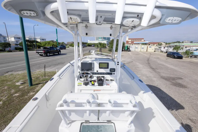 Slide: The Image of 2014 Sea Hunt Gamefish 25 boat with modern console and steering, parked near a road. - 11