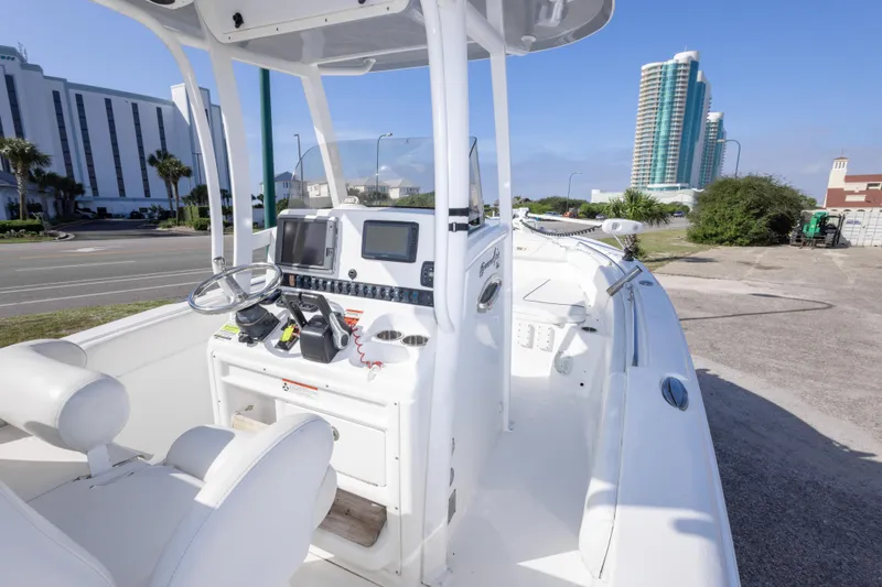 Slide: The Image of 2014 Sea Hunt Gamefish 25 boat interior with modern controls and cityscape background. - 16