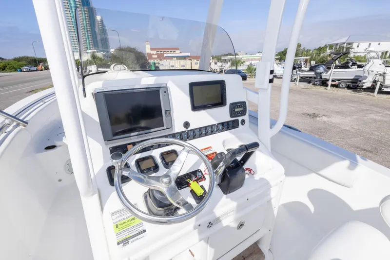 Slide: The Image of 2014 Sea Hunt Gamefish 25 boat console with steering wheel and navigation screens. - 18
