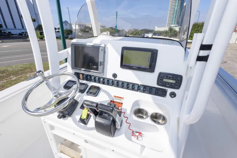 Slide: The Image of 2014 Sea Hunt Gamefish 25 boat console with steering wheel and navigation equipment. - 19