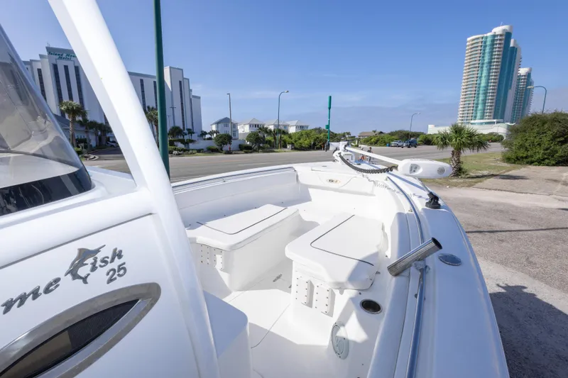 Slide: The Image of 2014 Sea Hunt Gamefish 25 boat docked near modern buildings, showcasing sleek design. - 20