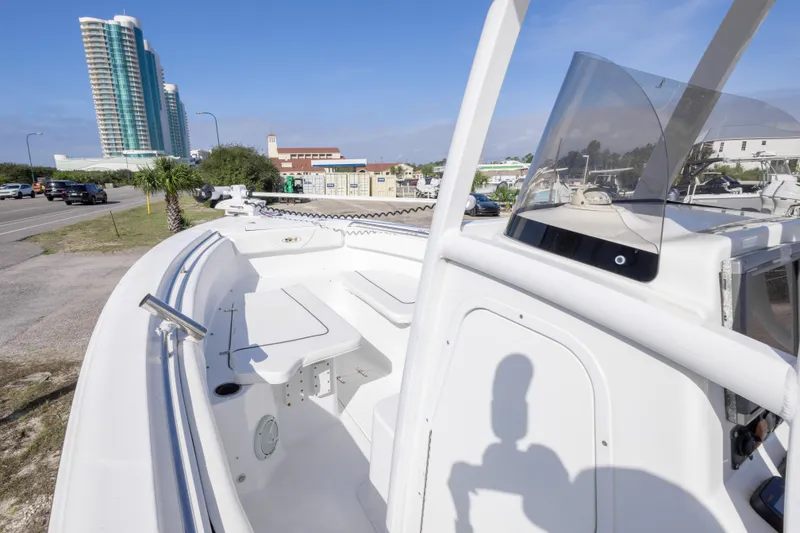 Slide: The Image of 2014 Sea Hunt Gamefish 25 boat docked near a coastal road with tall buildings. - 21