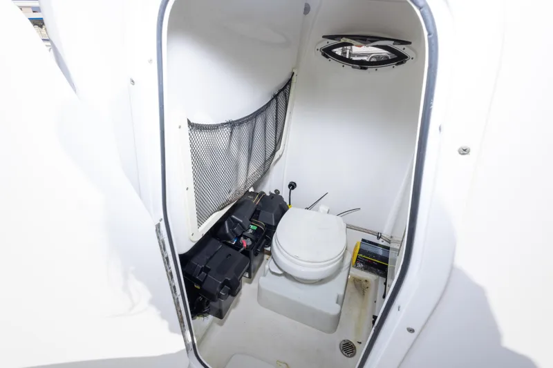 Slide: The Image of 2014 Sea Hunt Gamefish 25 boat interior with toilet and storage compartment. - 22