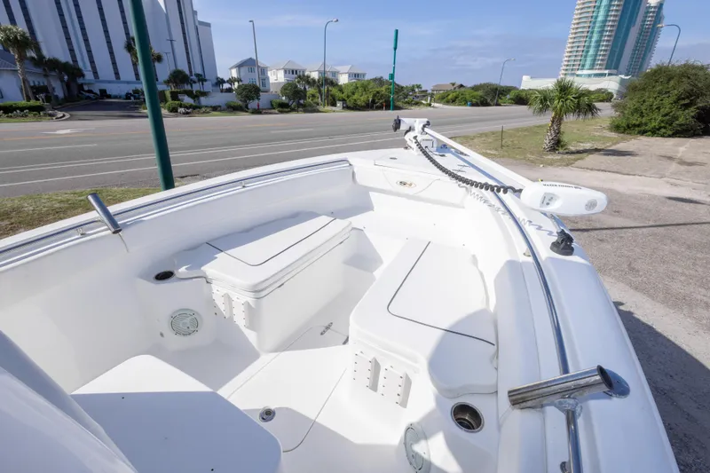Slide: The Image of 2014 Sea Hunt Gamefish 25 boat interior with seating and storage, docked near a road. - 24