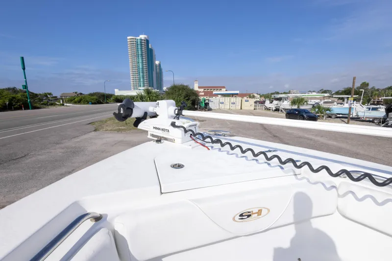 Slide: The Image of 2014 Sea Hunt Gamefish 25 boat with Minn Kota motor, urban backdrop, clear sky. - 25