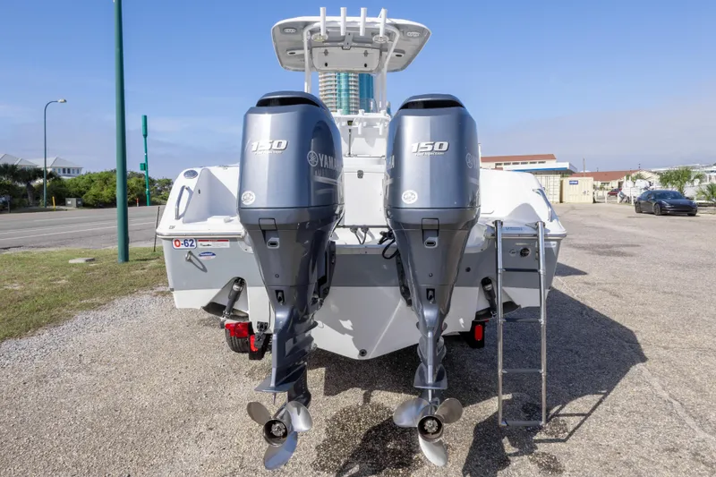Slide: The Image of 2014 Sea Hunt Gamefish 25 with twin Yamaha 150 engines, parked on gravel. - 3