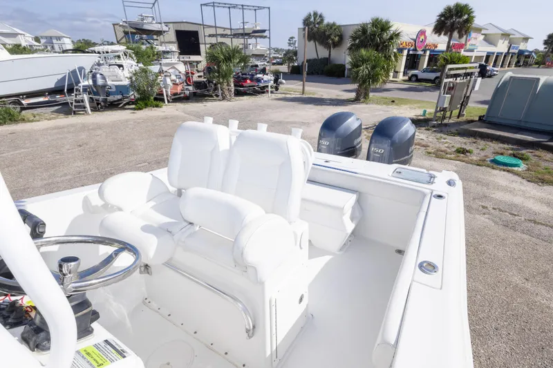 Slide: The Image of 2014 Sea Hunt Gamefish 25 boat with dual engines and white seating in a marina setting. - 32