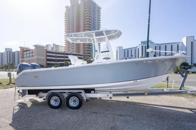 Slide: The Image of 2014 Sea Hunt Gamefish 25 boat on trailer, urban backdrop, sunny day. - 42