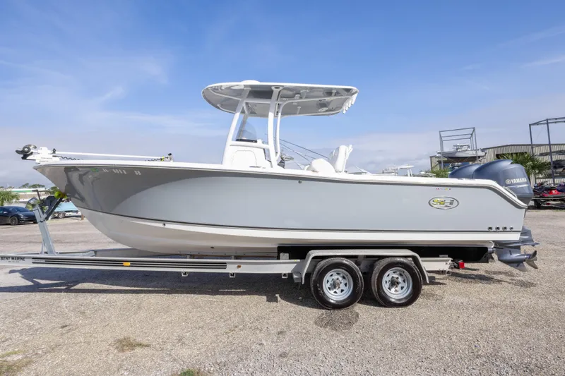 Slide: The Image of 2014 Sea Hunt Gamefish 25 boat on trailer, side view, clear sky background. - 43