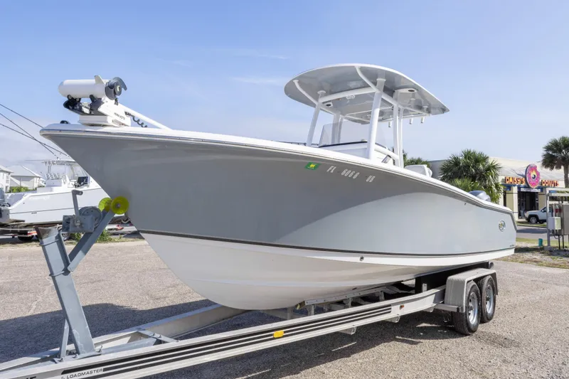 Slide: The Image of 2014 Sea Hunt Gamefish 25 boat on trailer, parked outdoors under clear sky. - 44