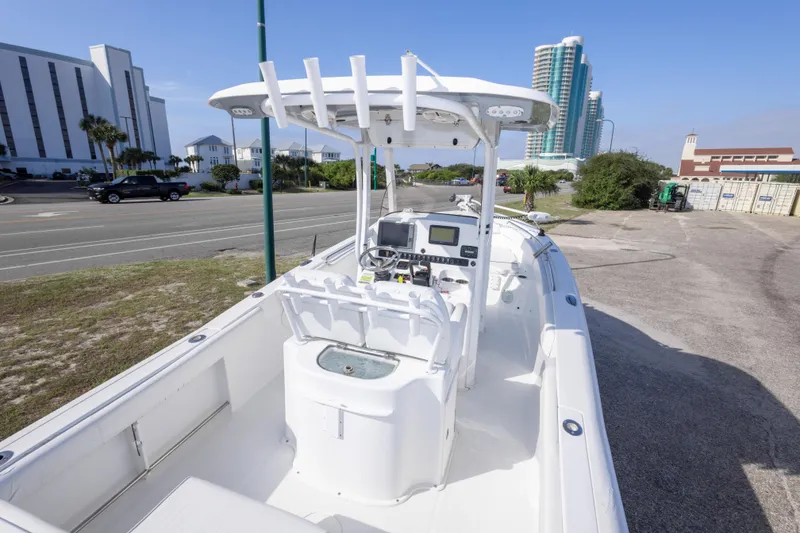Slide: The Image of 2014 Sea Hunt Gamefish 25 boat with console, parked near coastal buildings. - 9