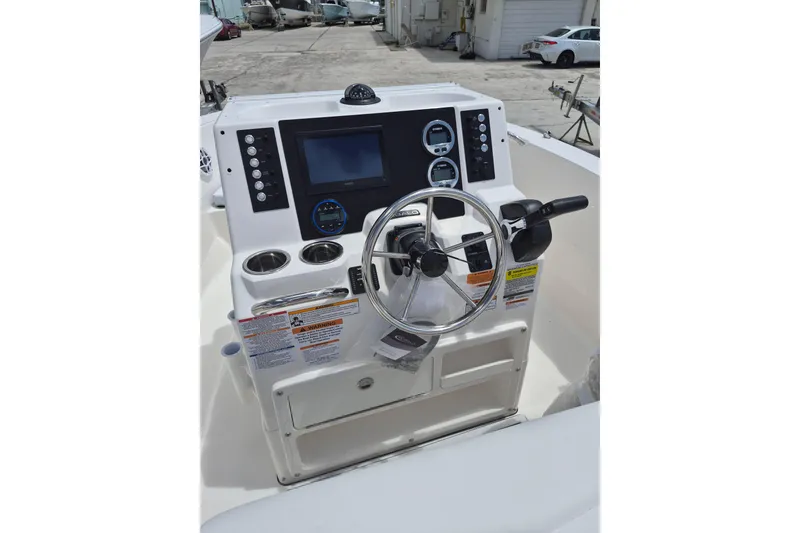 Slide: The Image of 2026 Robalo R180 Center Console boat dashboard with steering wheel and control panel. - 2