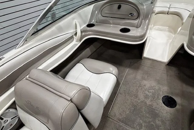 Slide: The Image of 2002 Sea Ray 182 Bow Rider interior with beige seating and cup holders. - 10