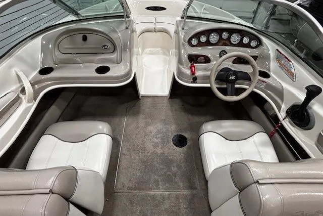Slide: The Image of 2002 Sea Ray 182 Bow Rider interior with beige seating and dashboard controls. - 23