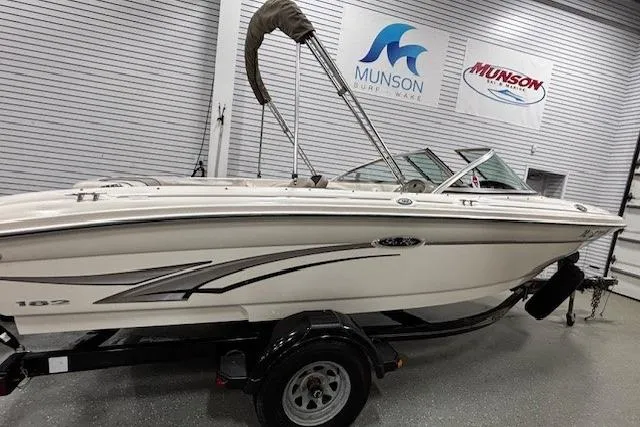 Slide: The Image of 2002 Sea Ray 182 Bow Rider boat on trailer in showroom with Munson signage. - 24