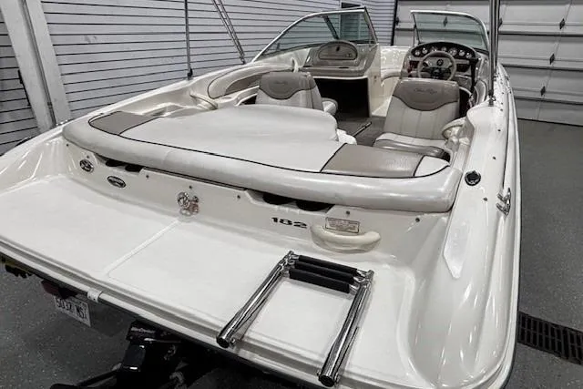 Slide: The Image of 2002 Sea Ray 182 Bow Rider boat in a garage, showcasing sleek design and comfortable seating. - 29