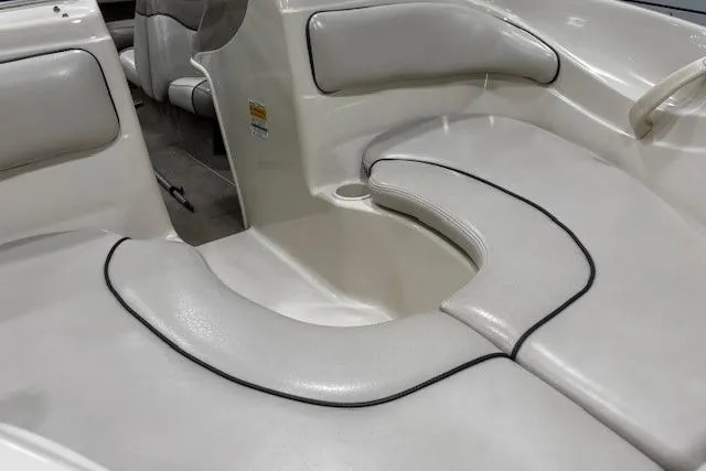 Slide: The Image of 2002 Sea Ray 182 Bow Rider interior with white cushioned seating and cup holder. - 35