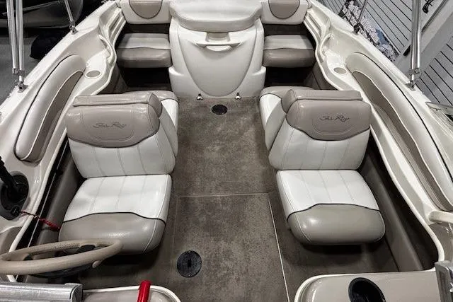 Slide: The Image of 2002 Sea Ray 182 Bow Rider interior with beige and white seating, spacious layout. - 8
