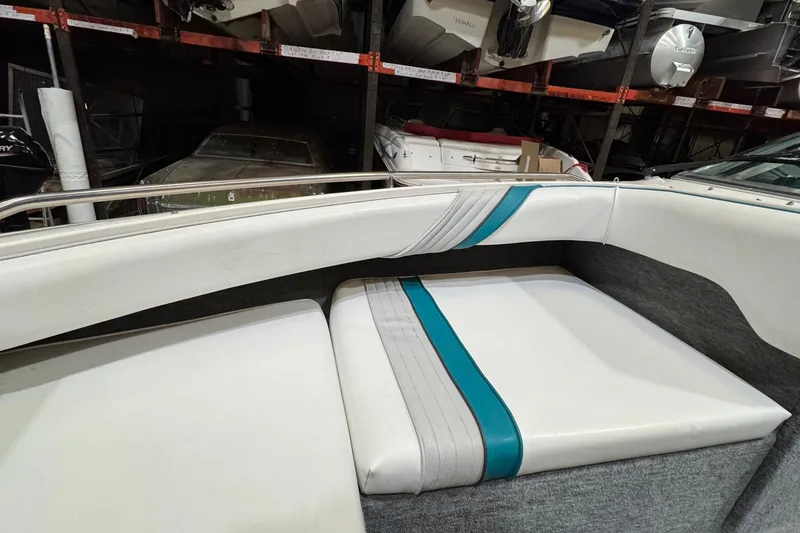 Slide: The Image of 1991 Sea Ray 185 Bow Rider interior with white and teal seating in storage. - 10
