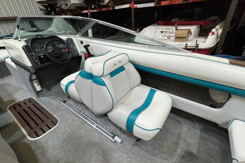 Slide: The Image of Interior of a 1991 Sea Ray 185 Bow Rider boat with white and teal seating. - 3