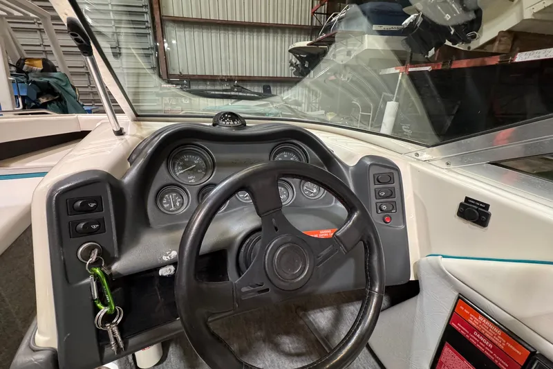 Slide: The Image of 1991 Sea Ray 185 Bow Rider dashboard with steering wheel and instrument panel in a garage setting. - 5