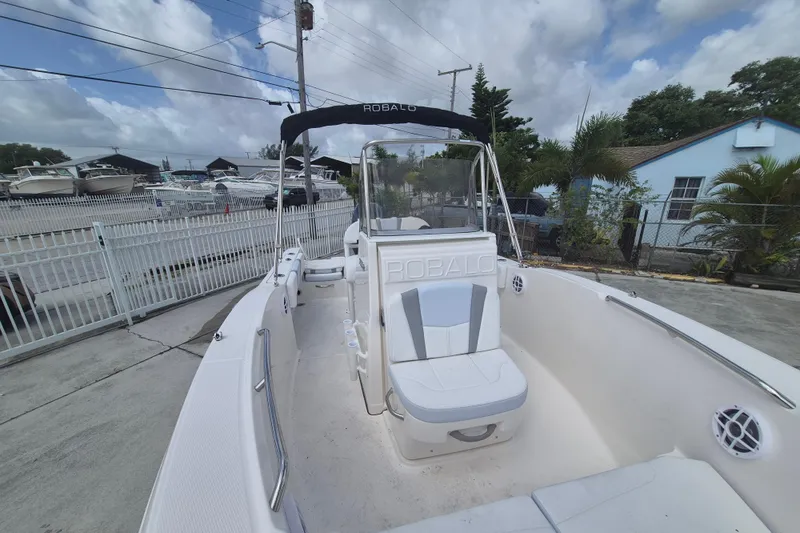 Slide: The Image of 2026 Robalo R180 Center Console boat docked outdoors under cloudy sky. - 11