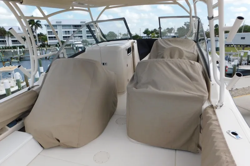 Slide: The Image of 2015 Grady-White Freedom 307 boat interior with covered seats at a marina. - 11