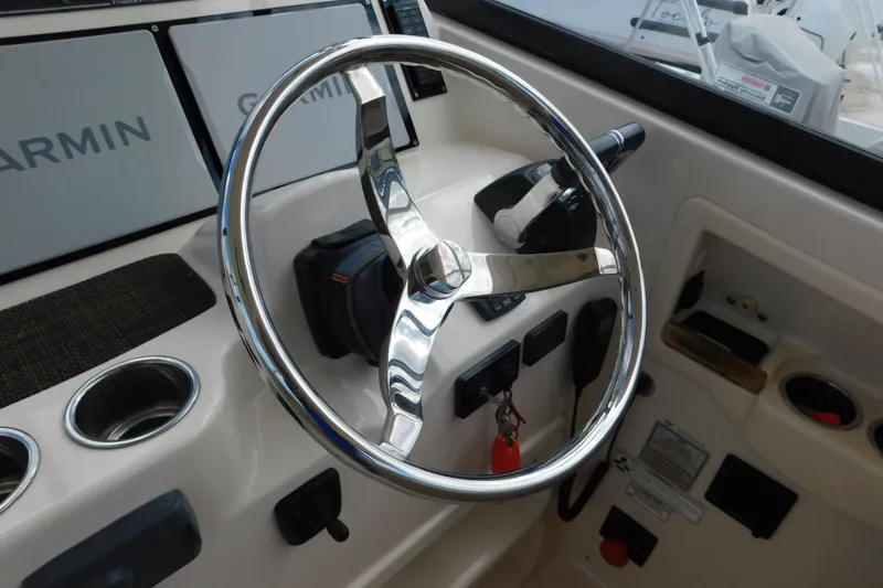 Slide: The Image of Steering wheel and controls of 2015 Grady-White Freedom 307 boat with Garmin displays. - 17