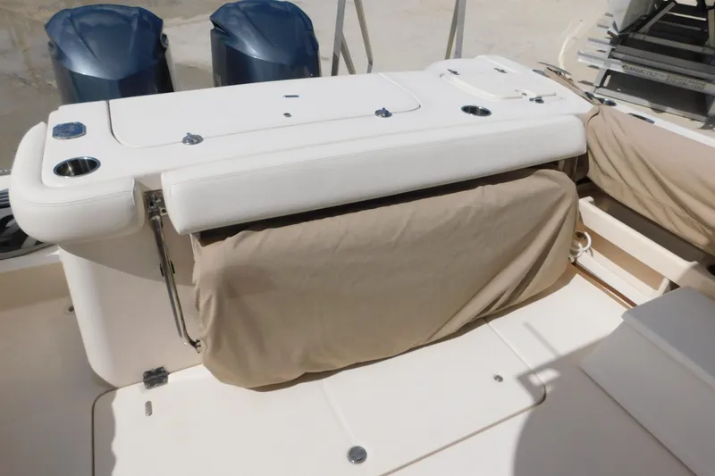 Slide: The Image of 2015 Grady-White Freedom 307 boat interior with cushioned seating and dual outboard motors. - 23